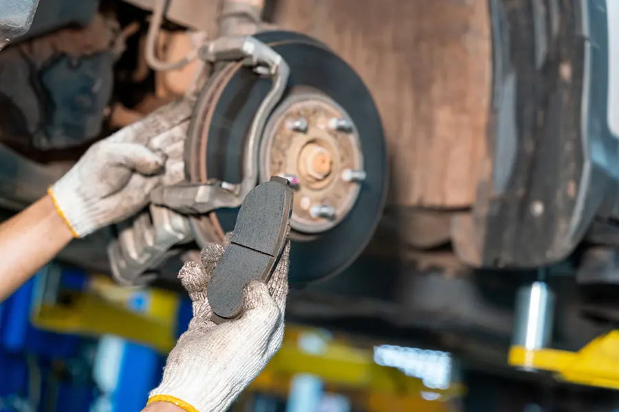 Mechanic inspecting and servicing brake components.