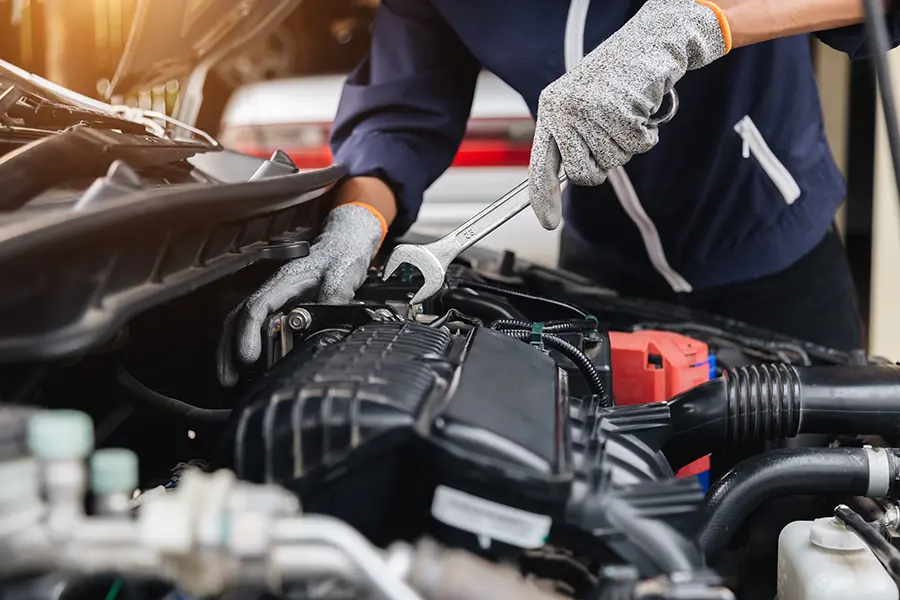 Mechanic using diagnostic tools to analyze car engine performance.